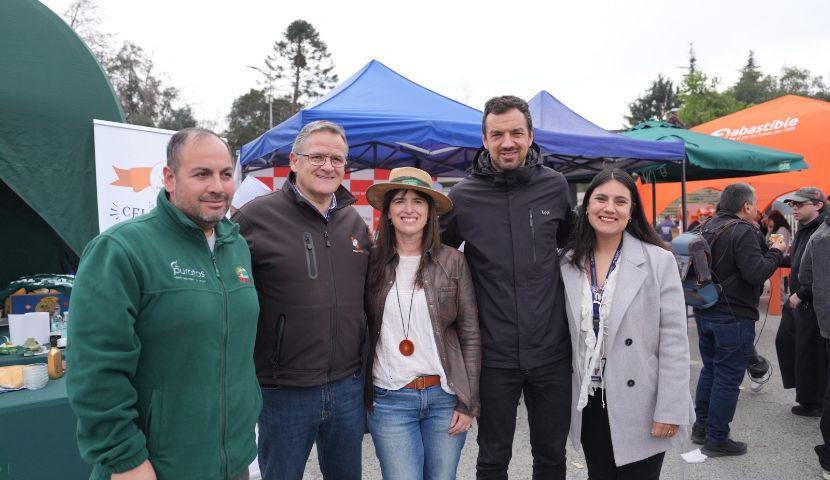 Vecinos de Maipú reunidos en torno a la parrilla durante la celebración del Día del Choripán en Marraqueta con San Jorge.